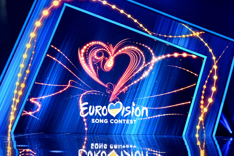 A stage with a lit background saying "Eurovision". The V is styled as a heart containing the Ukrainian flag.