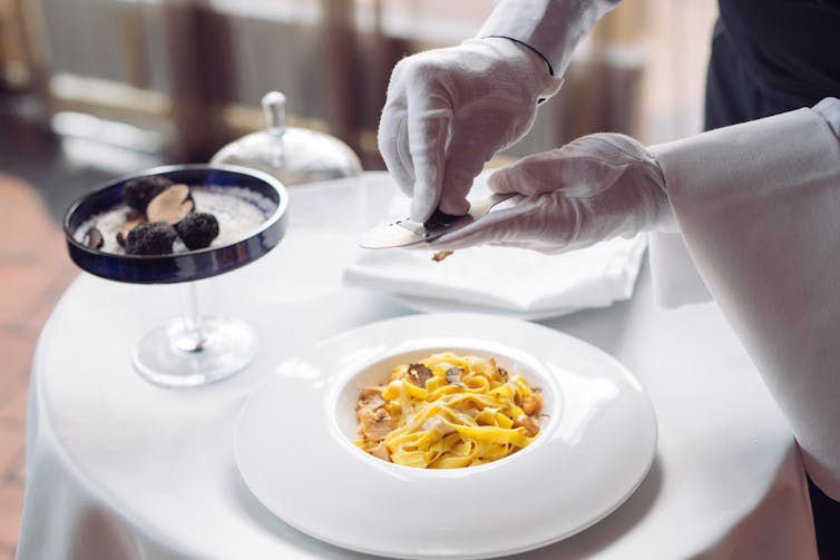 Truffles being grated onto pasta in an expensive restaurant.