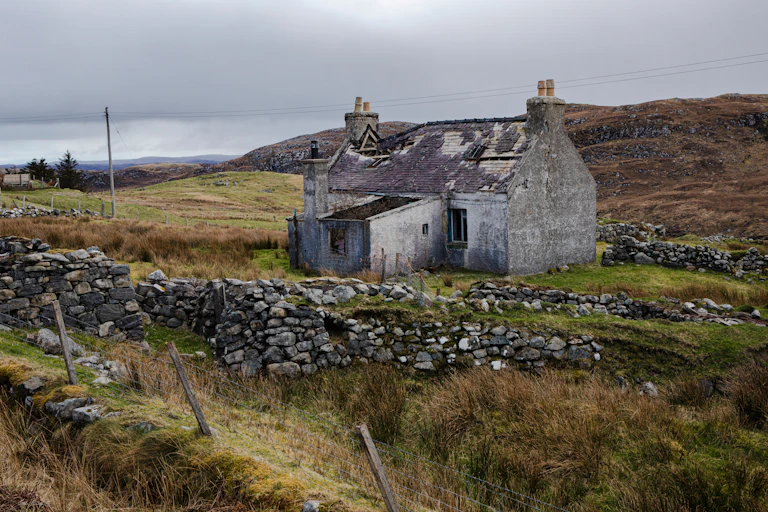 An abandoned, unmaintained house in a field in rural Scotland
