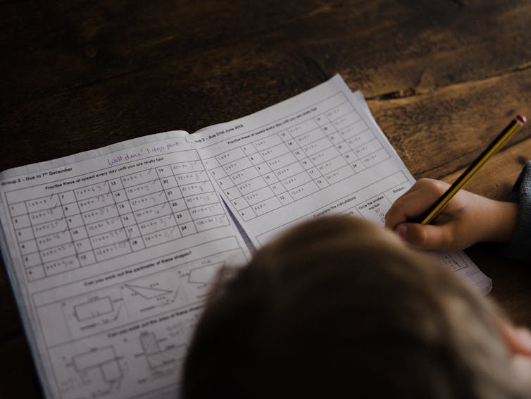 A child completes a maths worksheet.