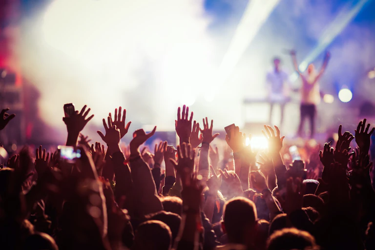 Multitud levantando las manos en un concierto.