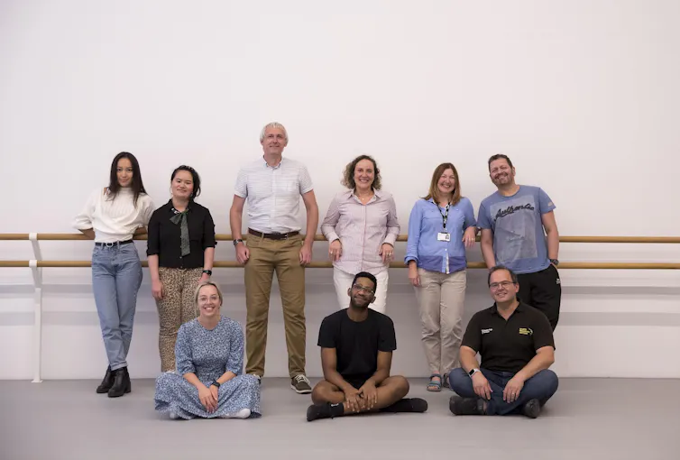 A group of people smiling in a ballet studio