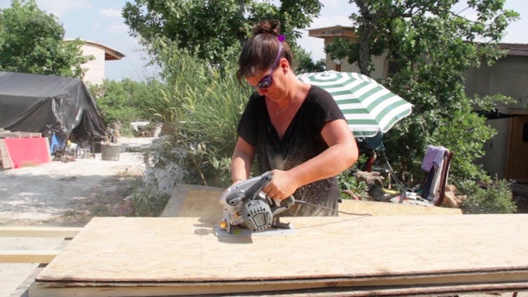 Une femme découpe une planche de bois