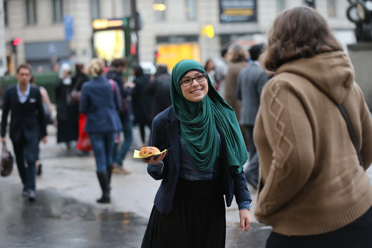 Une musulmane distribue un pain au chocolat