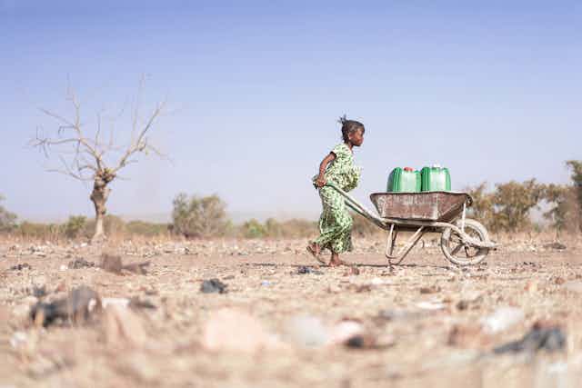 Little African Woman Transporting Fresh Water