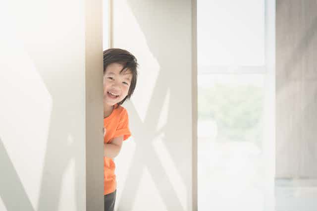 Little boy peering out from hiding place