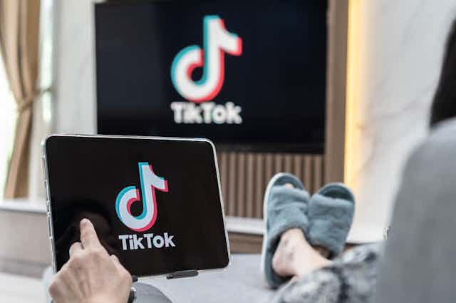 Un espectador ve TikTok en la pantalla de una tableta y en la televisión.