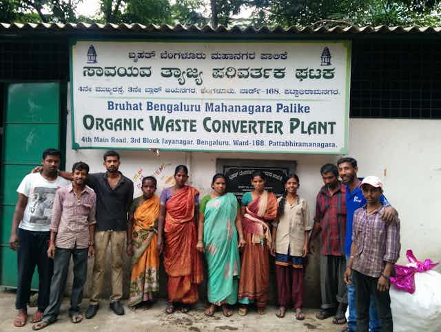 Waste management workers standing in front of a waste processing plant