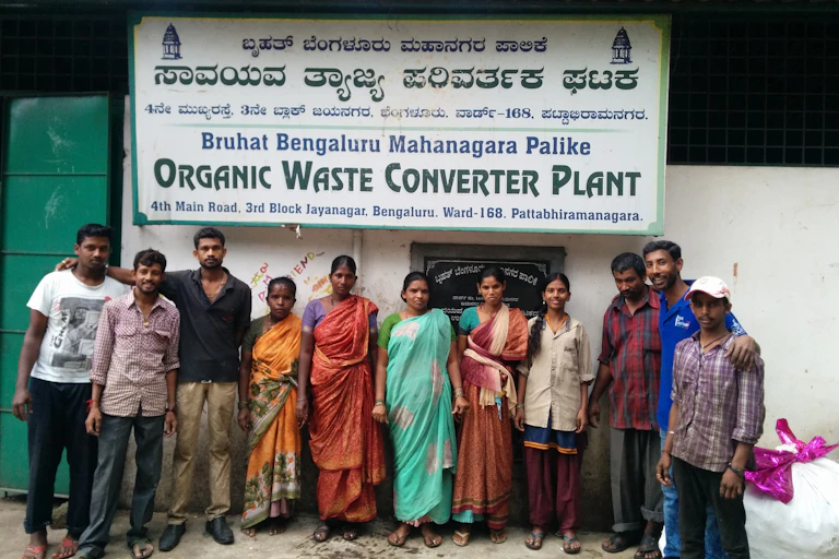 Waste management workers standing in front of a waste processing plant