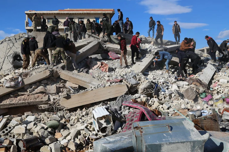 People scramble around rubble
