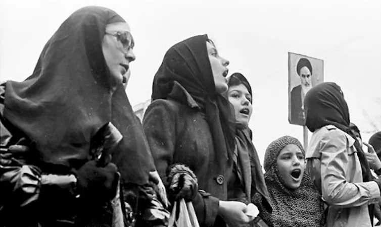 Iran 1979. Women protesters wearing hijabs and holding up a placard of the Ayatollah Khomeini.