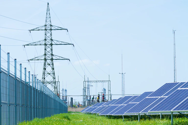 Panele solares junto a un tendido eléctrico.