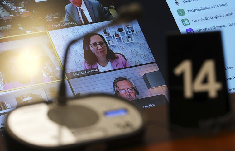 A computer screen displaying several people on a video call