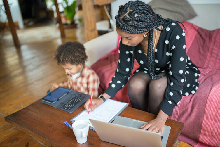 Mother and child on their devices next to eachother