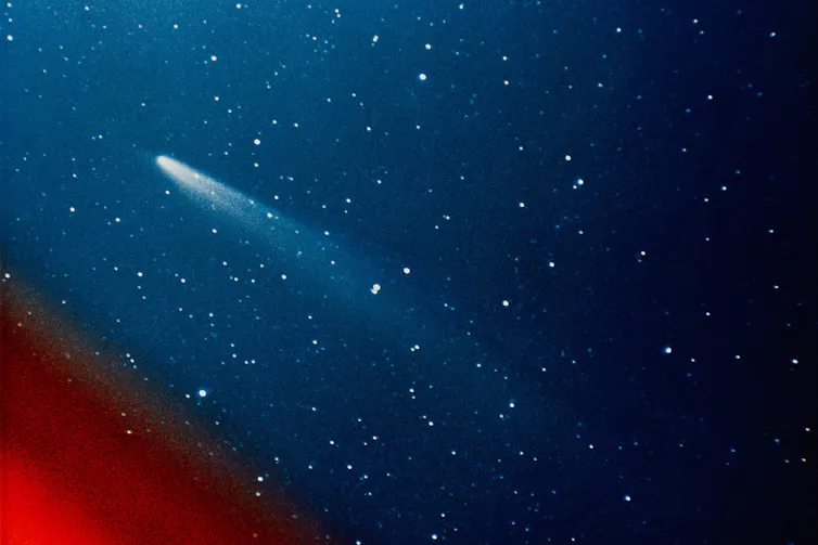 A blue star field with a red lower left corner and a bright streak angled towards top left