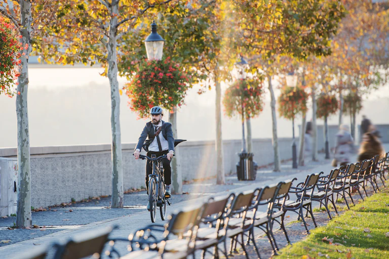 Man in suit rides along a city cycle path to work