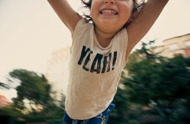 child swinging from arms with happy smile