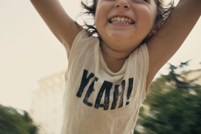 child swinging from arms with happy smile