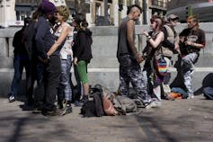 Un grupo de punkis hablando y abrazándose en una plaza madrileña.