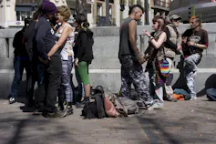 Un grupo de punkis hablando y abrazándose en una plaza madrileña.