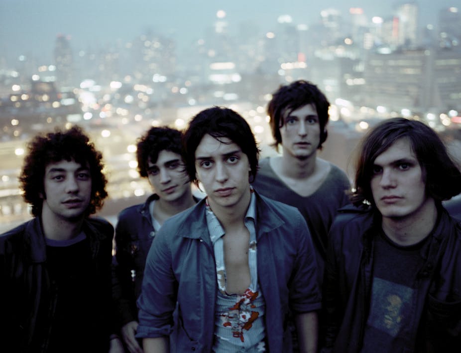 Five members of the Strokes stand in front of the New York skyline.