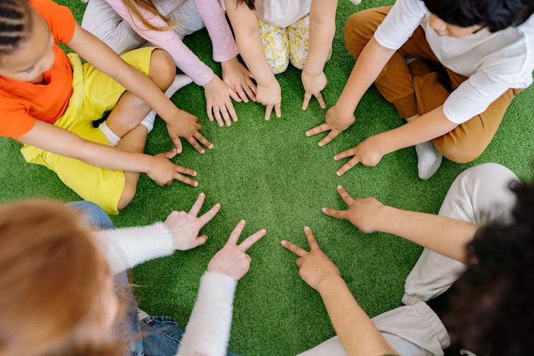 Hands of children seen in a circle.