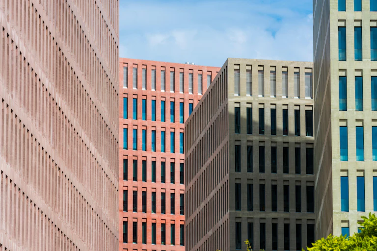 Coloured walls of windows against a pale blue sky.