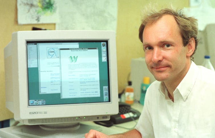 a photograph of a man sitting in front of a cathode ray tube computer monitor