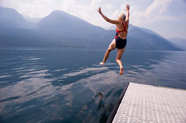 Older adult jumping into lake
