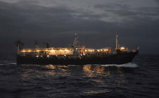 Fishing vessel at night with bright lights