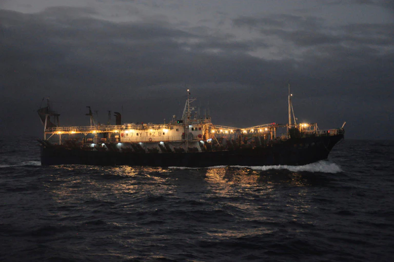 Fishing vessel at night with bright lights