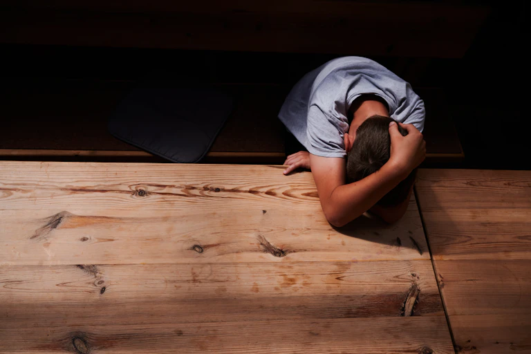 A boy huddled over a desk