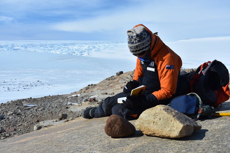 Jamey Stutz samples two ice-transported cobbles (rocks) at Hughes Bluff in Victoria Land, Antarctica.