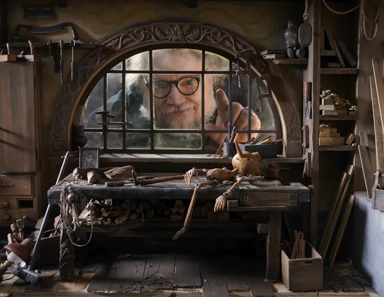Guillermo del Toro looks through a window in the Pinocchio set.