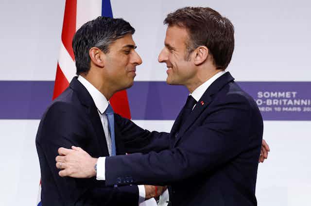 Rishi Sunak and Emmanuel Macron embracing.