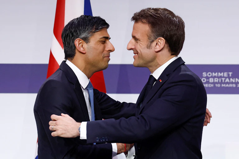 Rishi Sunak and Emmanuel Macron embracing.