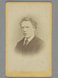 A faded portrait of a young man in a suit.