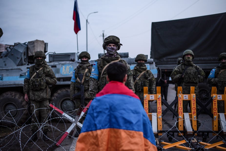 Un manifestant arménien face à des soldats russes