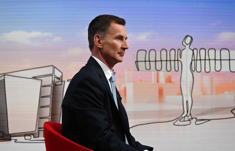 Jeremy Hunt in a TV studio sitting in front of a cartoon of the Angel of the North.