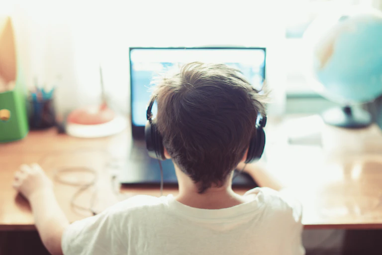 A young boy using a laptop.
