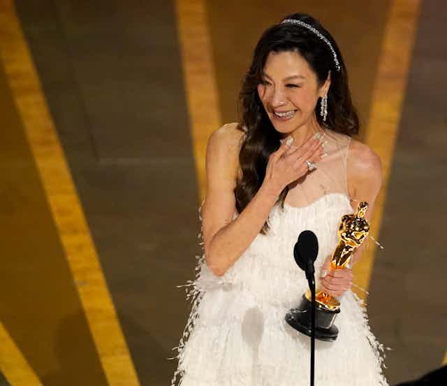 A woman holds an Oscar.