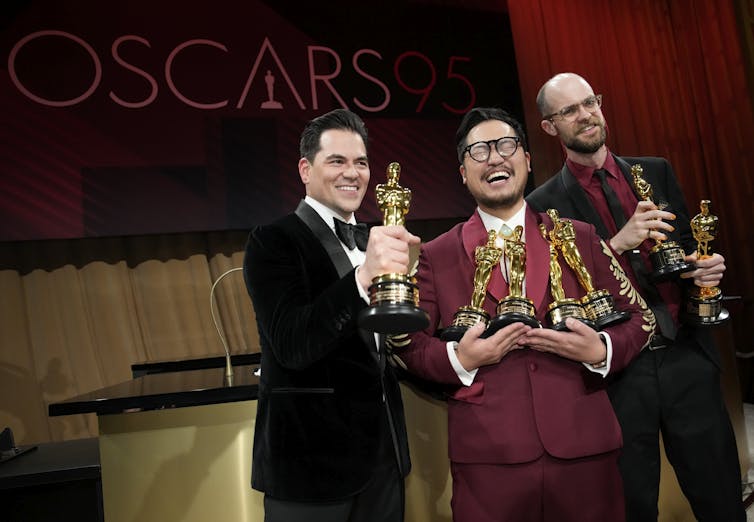 Three men seen holding Oscars.