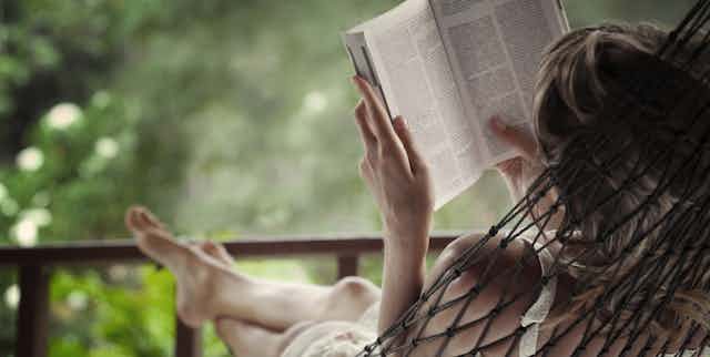 Woman in hammock reading a book.