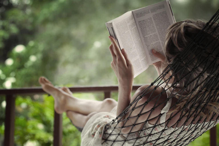 Woman in hammock reading a book.