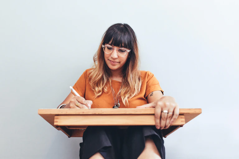 Woman sketching on wooden board.