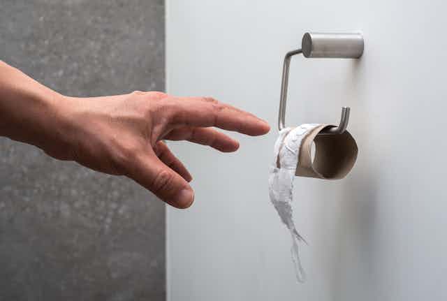 hand reaches for last of toilet paper