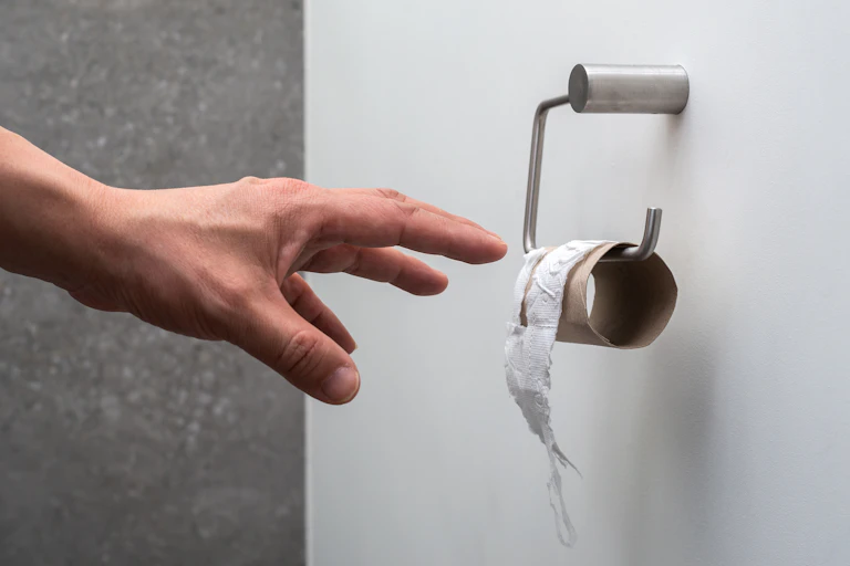 hand reaches for last of toilet paper