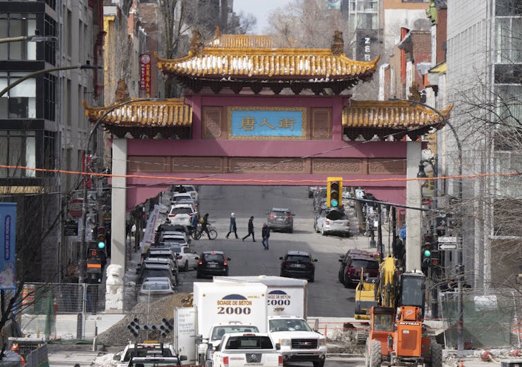 A Chinese style red and gold gateway above a road.