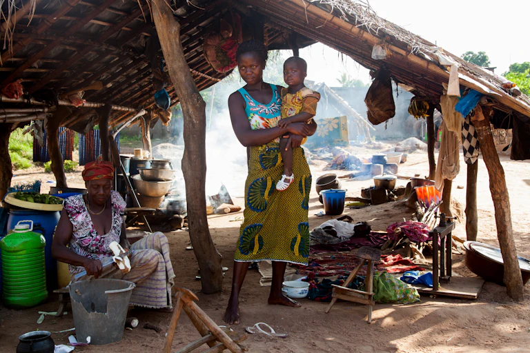 Une femme africaine cuisine dans un village.