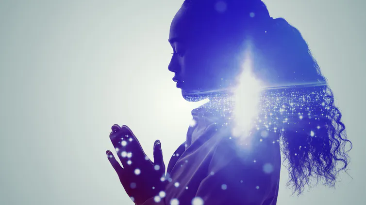 a galaxy with a bright light within a woman's silhouette